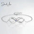 Silver infinity bracelet with engraved names on a light gray background, featuring the brand 'Jewel Aus'.