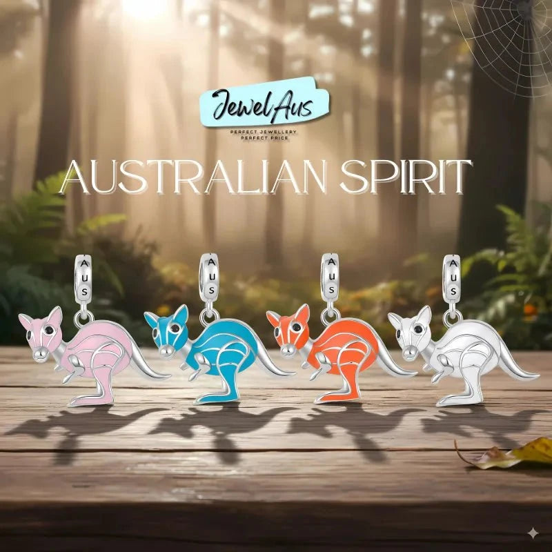 Colorful kangaroo-shaped charms on a wooden surface with a forest background, featuring the brand 'Jewel Aus'.