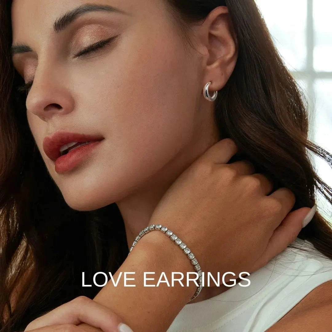 Close-up of a woman wearing silver hoop earrings and bracelet with 'LOVE EARRINGS' text.