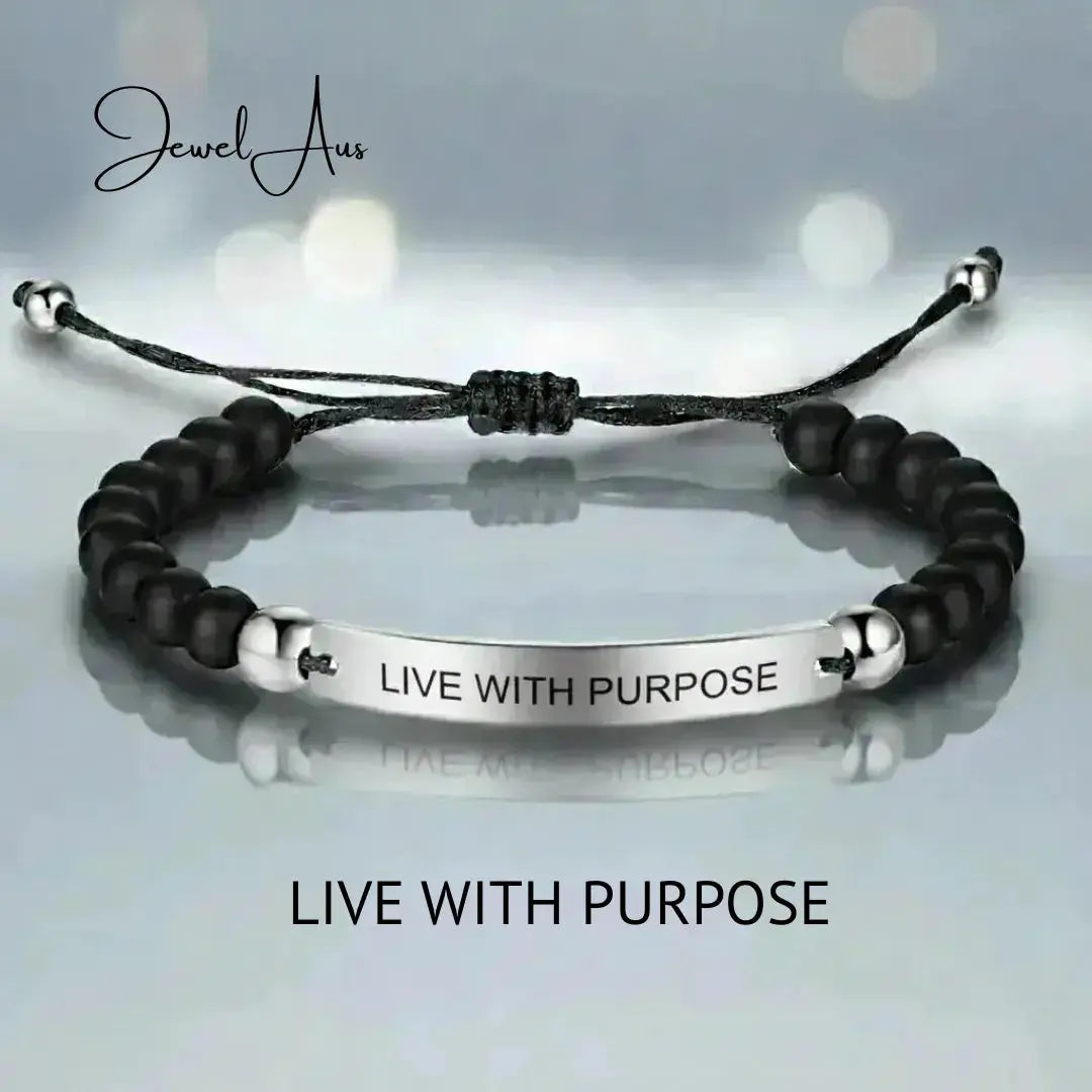 Black beaded bracelet with silver bar and 'Live with Purpose' engraving on a light gray background.
