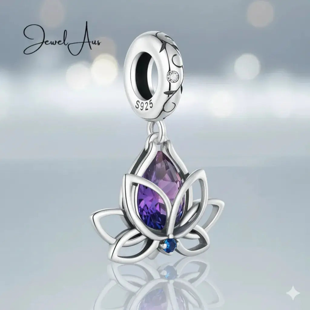 Silver pendant with purple gemstone on a reflective surface