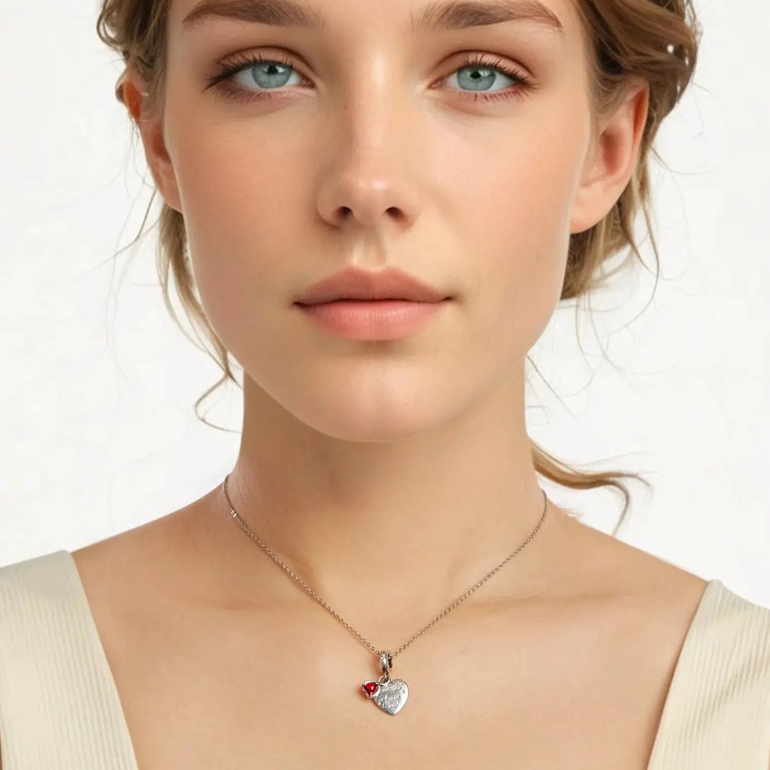Woman wearing a necklace with a heart-shaped pendant on a plain background