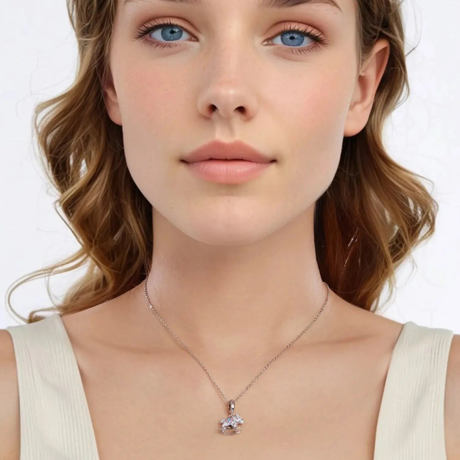 Woman wearing a delicate necklace with a small pendant on a plain background