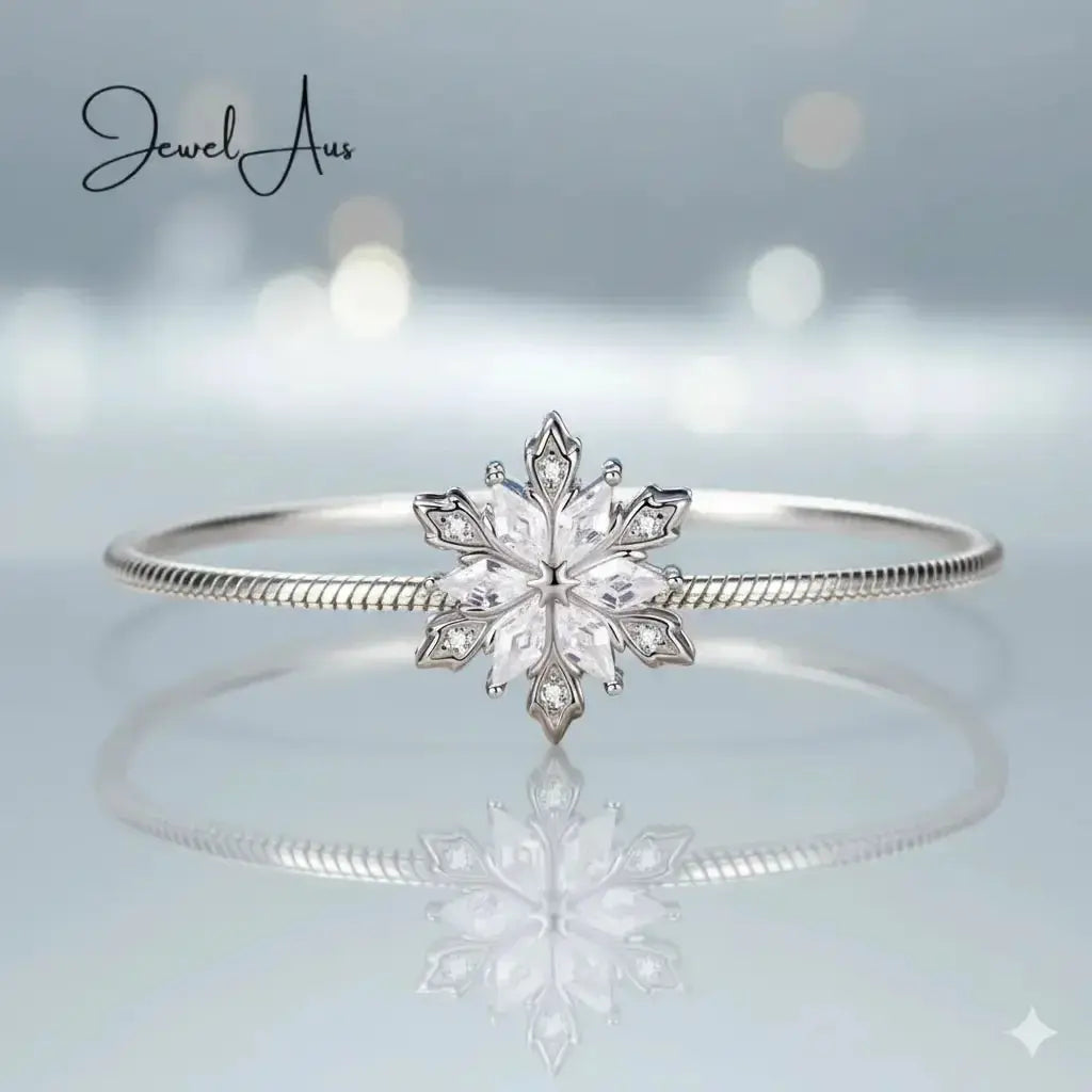 Silver bracelet with a snowflake design on a light gray background