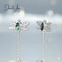 Dragonfly-shaped earrings with green gemstones on a light blue background, branded 'Jewel Aux'.