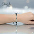 Bracelet on a wrist with a blurred background, featuring the brand 'Jewel A'.