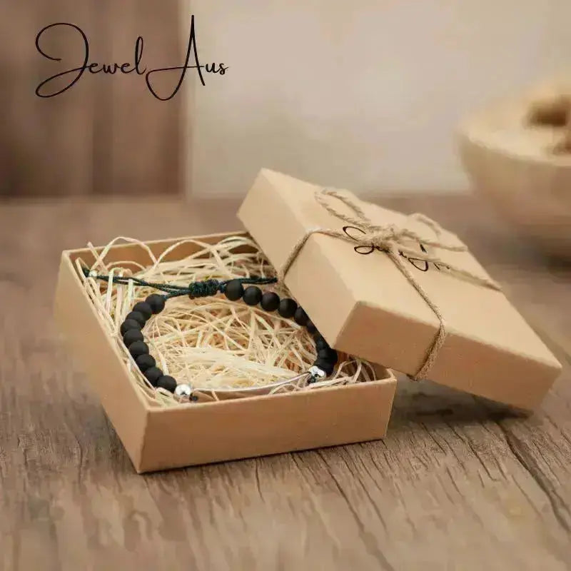 Bracelet in a brown gift box on a wooden surface with 'Jewel Aus' branding.