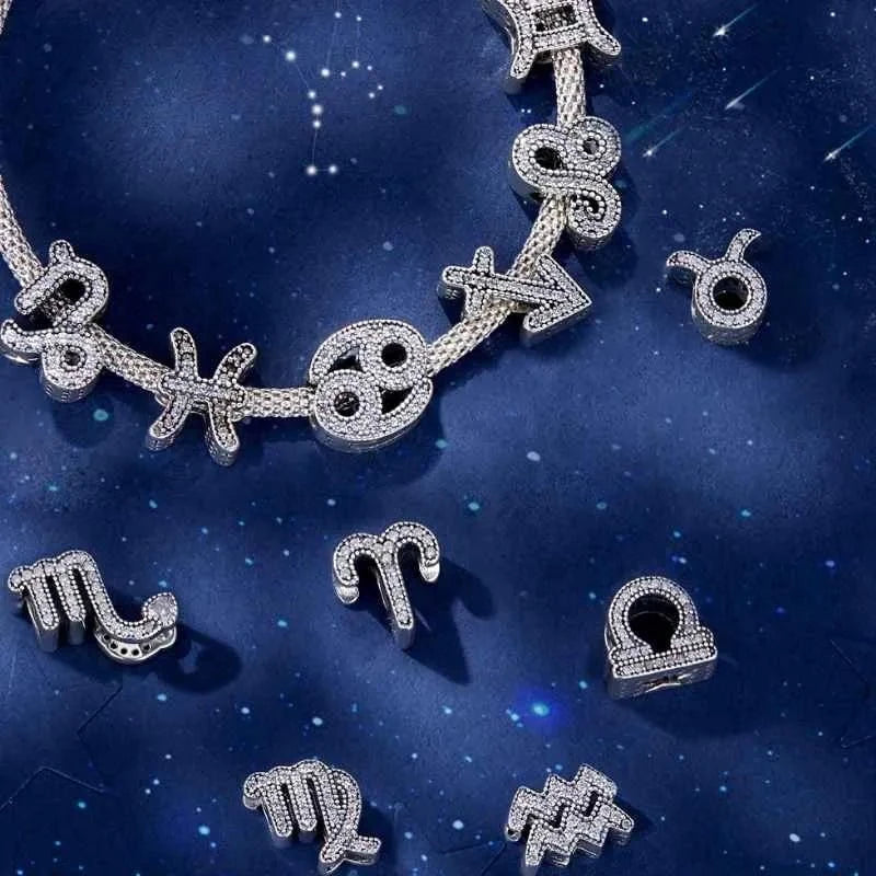 Silver zodiac charm necklace and individual charms on a starry night sky background